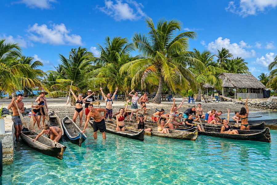 A big group of travelers with traditional canoes on a San Blas island