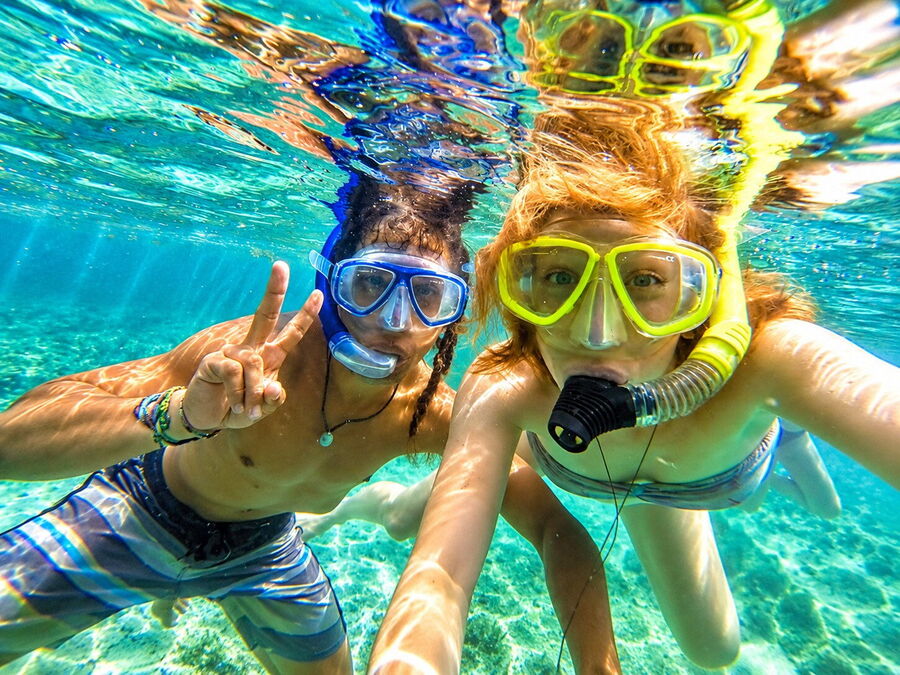 Two travelers snorkeling in the clear turquoise water of San Blas
