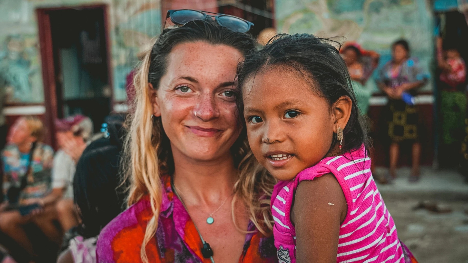 A traveller and a Guna girl smiling together in an island community