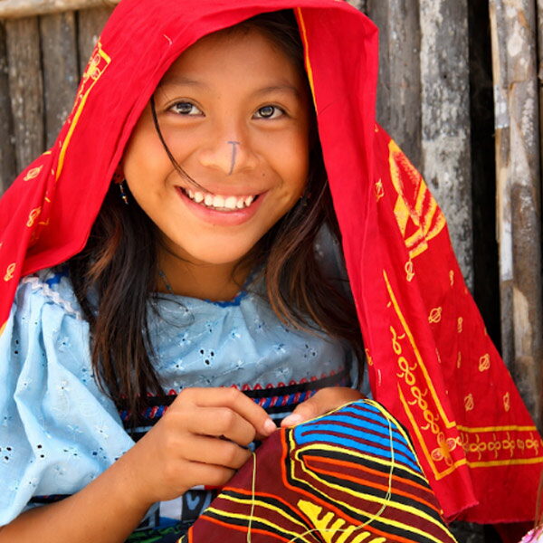 Guna girl sewing a traditional mola in her community